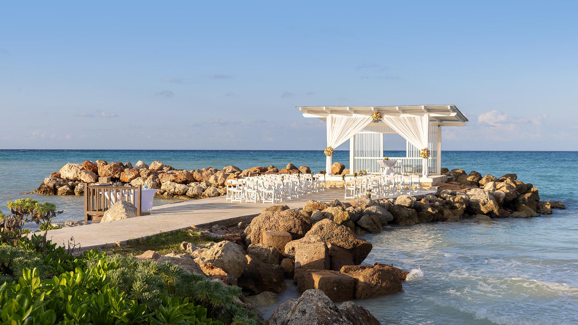A beautiful wedding ceremony setup on a pier overlooking the ocean at Royalton Blue Waters