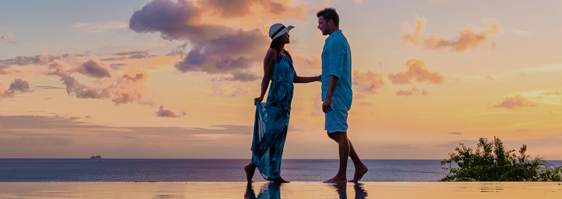 Couple standing on the beach at sunset