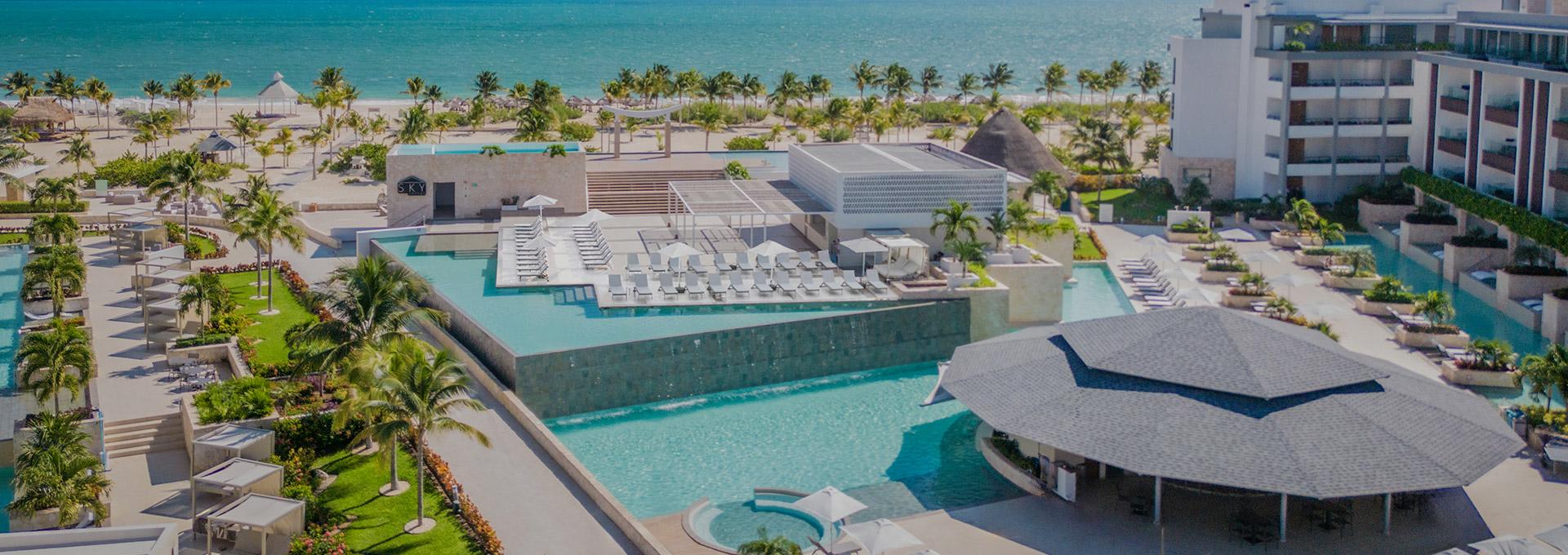 Aerial view of the stunning pools and beachfront at Majestic Elegance Costa Mujeres, your perfect Caribbean escape.