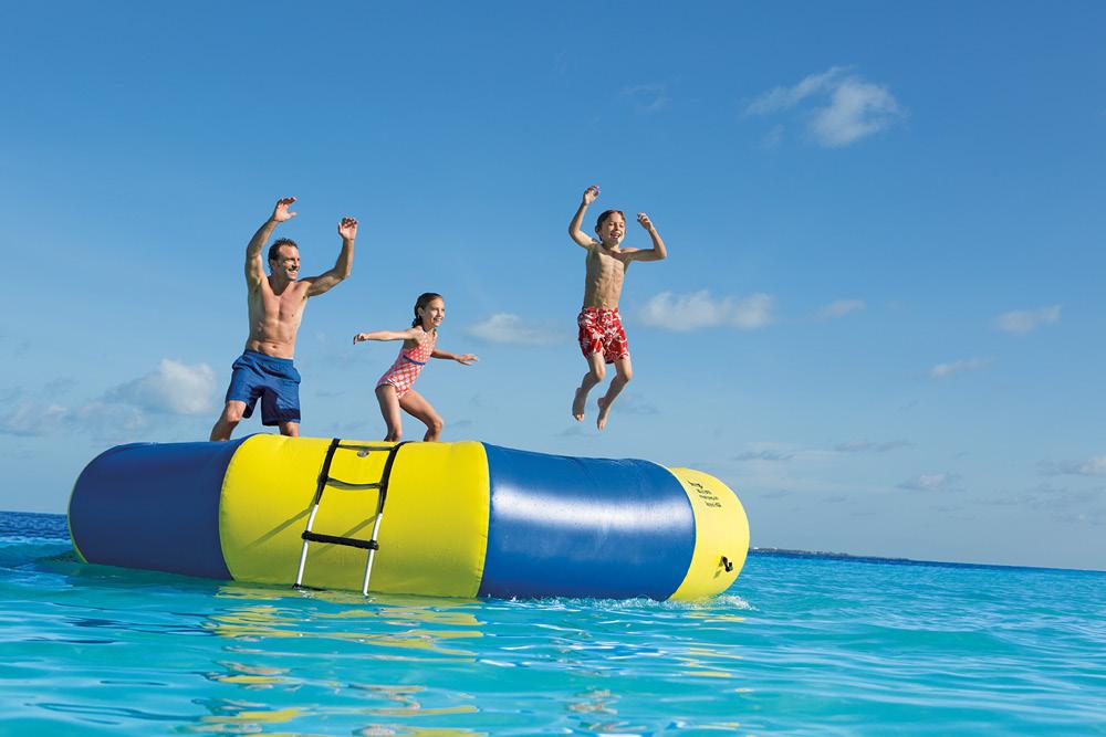 Family jumping on water trampoline at Dreams® Sands Cancun Resort & Spa